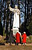 011_25883 | die Statue "Predigender Christus" wurde 1905 aus Marmor gefertigt; Bildhauer Xaver Arnold. Friedhofs - Besucherinnen stehen vor der Skulptur und znden Kerzen an.