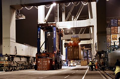 011_25880 | der Portalhubstapelwagen nimmt einen Container auf whrend schon ein weiterer Container vom Containerschiff entladen wurde.