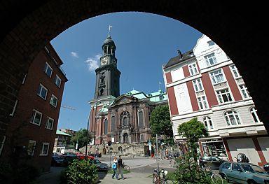011_25848 | Die St. Michaeliskirche, kurz Michel genannt, wurde von 1641-1661 erbaut, 1750 durch Brand zerstrt; 1762  aufgebaut; 1906 wieder durch Brand zerstrt u. 1912 neu eingeweiht. Der Kirchturm gilt als das Wahrzeichen Hamburgs; betrachtet durch den Torbogen der Wohngebude der Schiffszimmerergenossenschaft.