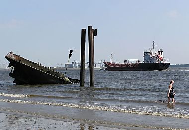 11_25829 | Schiffswrack am Elbufer bei Wittenberge; ein Frachter fhrt Richtung Hamburg Hafen.
