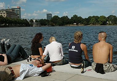 011_25825 | Jugendliche liegen in der Sonne am Alsteranleger Jungfenstieg; im Hintergrund lks. Huser Neuer Jungfernstieg / Esplanade.