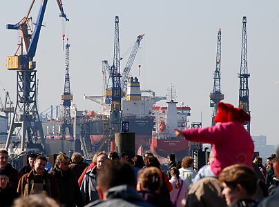 011_259001 | Spaziergnger in der Frhlingssonne am Hamburger Hafen / Baumwall; im Hintergrund die Krne der Werft Blohm + Voss - zwei Schiffe liegen zur Reparatur im Trockendock.