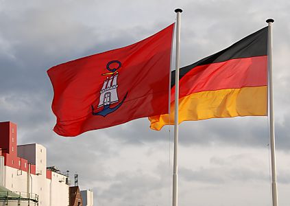 011_25992 | das Hamburg Wappen, die weisse Burg mit den drei Trmen und dem geschlossenen Tor auf der roten Fahne. Der blaue Anker zeigt Hamburg als Hafenstadt - es ist die Hamburger Hafenflagge. Rechts daneben die deutsche Nationalflagge, schwarz, rot, gold.  