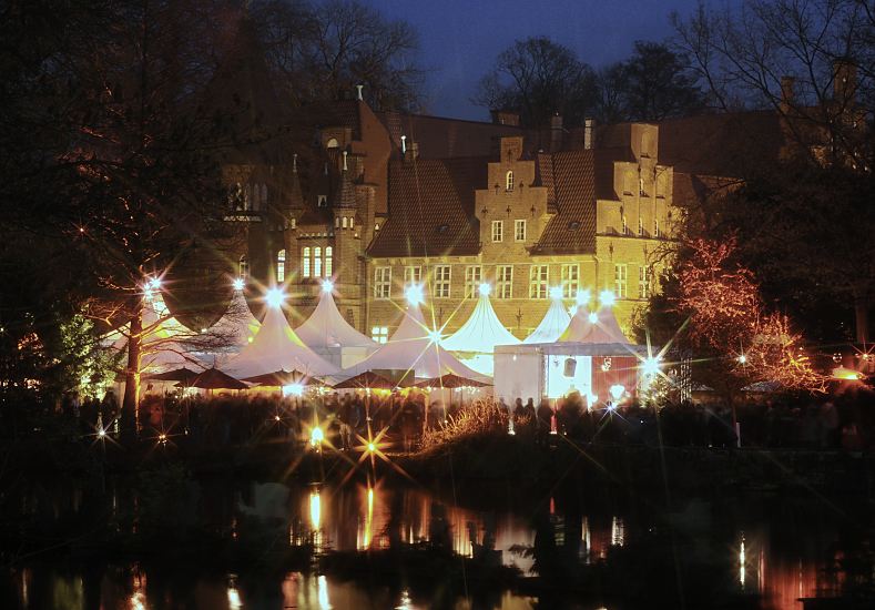 4288_21477 Vor dem historischen Bergedorfer Schloss ist ein Weihnachtsmarkt aufgebaut - die Sterne auf den Zeltspitzen leuchten hell - das weihnachtliche Licht spiegelt sich im Schlossteich wieder.