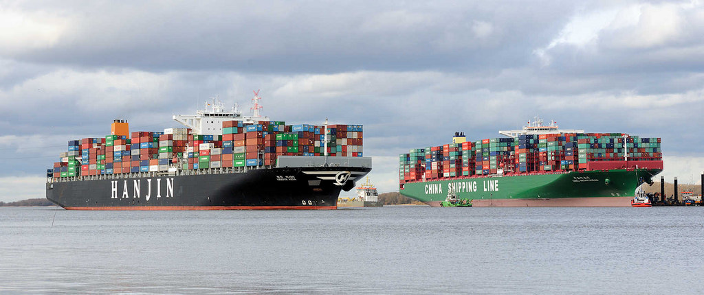 7788 Der Containerfrachter Hanjin Asia fhrt auf der Elbe bei Stade - daneben die festgefahrene, havarierte CSCL Indian Ocean.