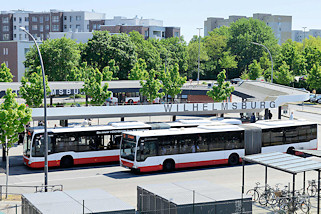 0396 Blick auf den Busbahnhof Hamburg Wilhelmsburg - ein Gelenkbus steht an der Haltestelle, ein weiterer Bus fhrt ab.