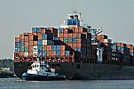 011_25839 | ein Schlepper dirigiert das Heck eines Frachtschiffs auf der Elbe - die Container sind hoch auf dem Heck vom Containerschiff gestapelt .