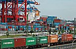011_25843 | Arbeit im Hafen Hamburg; im Vordergrund transportiert ein Gterzug die Container aus dem Hafengebiet; im dahinter sind entladene Container gelagert - ein Frachtschiff liegt am Hafen Kai.