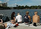 011_25825 | Jugendliche liegen in der Sonne am Alsteranleger Jungfenstieg; im Hintergrund lks. Huser Neuer Jungfernstieg / Esplanade.
