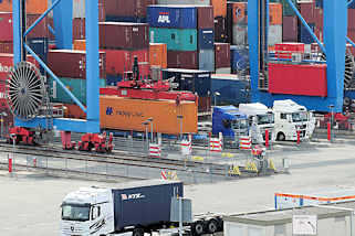8240 Sattelschlepper / LKW stehen unter dem Portalkran auf dem Gelände vom Hamburger Container Terminal Altenwerder. 