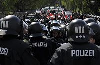 011_26017 |  am 1. Mai 2008 hat die NPD und andere Neonazis einen Aufmarsch durch den Hamburger Arbeiterviertel Barmbek geplant. Ein breites Bndnis gegen Rechts hat eine Gegendemonstration organisiert -  u.a. unter dem Motto " Faschismus ist keine Meinung sondern ein Verbrechen." Auf dem Bild sammeln sich die Neonazis am Bahnhof Alte Whr - Polizisten in Kampfanzug mit Helm sichern den NPD Trupp.