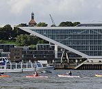 011_26028 | KajakfahrterInnen kommen von der Sderelbe / Khlbrand und fahren mit ihre Kajaks in die Elbe bei Neumhlen ein. Ein Schiff der Hamburger Hafenrundfahrt passiert die Paddler sehr nahe, die darauf warten durch die Wellen und der starken Strmung zur anderen Elbseite paddeln zu knnen.  Hinter der modernen Architektur des Brogebude Dockland am ehemaligen Ausrstungskai vom Altonaer Hafen ist hoch oben die Christianskirche von Hamburg Altona zu erkennen. www.christoph-bellin.de