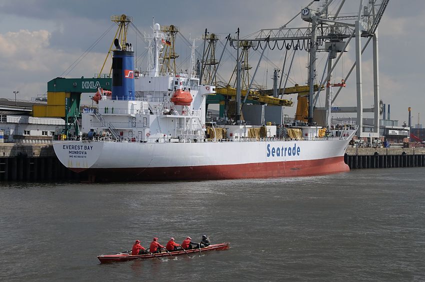 011_26029 |  Fotos von Hamburger Hafen :: Bilder von Frachtschiffen :: Ein Ruderboot, Vierer mit Steuermann, fhrt durch ein Hafenbecken im Hamburger Hafen - am gegenber liegenden Kai hat das Frachtschiff Everest Bay aus Monrovia fest gemacht.  www.christoph-bellin.de