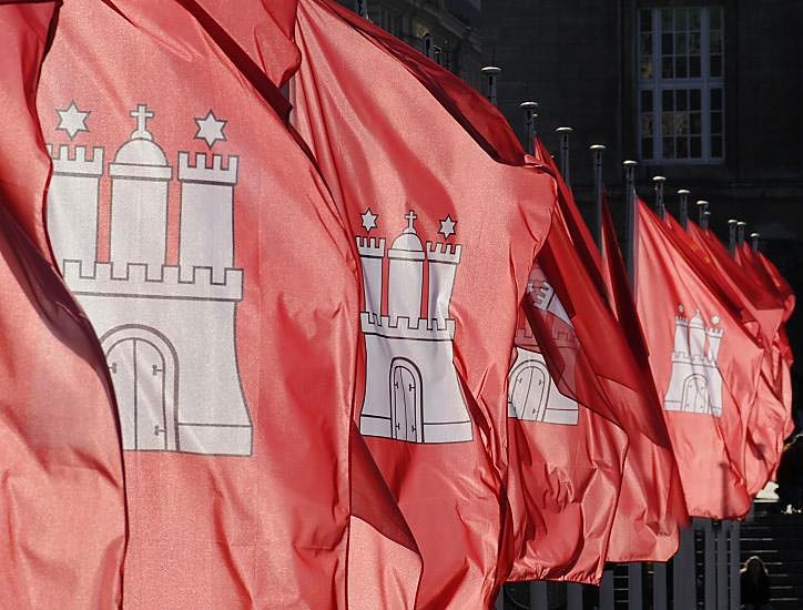 011_26038 | Die Hamburger Landesflaggen wehen Wind - auf rotem Grund steht das Hamburger Wappenzeichen die Burg mit drei Trmen, Burgzinnen und geschlossenem Burgtor. Der mittlere Turm mit dem Kreuz auf der Turmspitze symbolisiert den mittelalterlichen Hamburger Dom, die beiden Trme mit den Sternen ber den Turmzinnen sind Mariensterne, die an die Schutzpatroninnen der Stadt, Maria, erinnern sollen.  www.christoph-bellin.de