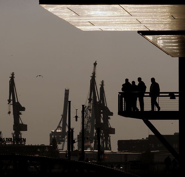 011_26042 | Abenddmmerung im  Hamburger Hafen - Krane stehen sind als Silhouette an Hamburgs Abendhimmel zu sehen. Hamburg-Touristen stehen auf der Aussichtsplattform in der Hafencity am Sandtorhafen und blicken auf die Elbe. www.christoph-bellin.de