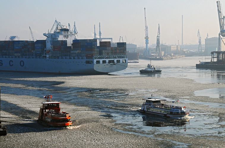 41_656541 |  Eisgang auf der Elbe - Hafenfhren bahnen sich ihren Weg durch die Eisschollen auf dem Wasser im Hamburger Hafen. Ein Containerriese ist in den Hafen eingelaufen und wird von einem Schlepper rckwrts zu seinem Liegeplatz am Container Terminal Tollerort gezogen. Die Ausleger der Hafenkrane stecken sich in den dunstigen Winterhimmel Hamburgs.  www.fotograf-hamburg.de 