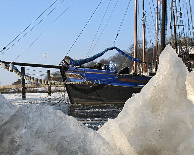 41_656543 |  Die Wintersonne scheint auf die Eisschollen im Museumshafen in Hamburg velgnne; ein historisches Segelboot mit Bugsprit und Takelage berwintert dort. In dem Museumshafen knnen grosse historische Maschinenfahrzeugen wie z.B. der Eisbrecher Stettin oder Segelschiffe und Schwimmkrne besichtigt werden.  www.fotograf-hamburg.de