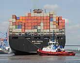 89-8029 |  Das Containerschiff NYK Vesta ist hoch mit Containern beladen - ein Hafenschlepper untersttzt den Frachter bei der Ausfahrt aus dem Hamburger Hafen. Die NYK VESTA hat eine Breite von 45,60m und eine Lnge von 338m. Mit 8600 TEU voll beladen hat das Frachtschiff einen Tiefgang von 14,50m und kann bei einer Maschinenleistung von ca. 87000 PS 24,5 kn fahren. www.fotograf-hamburg.de 