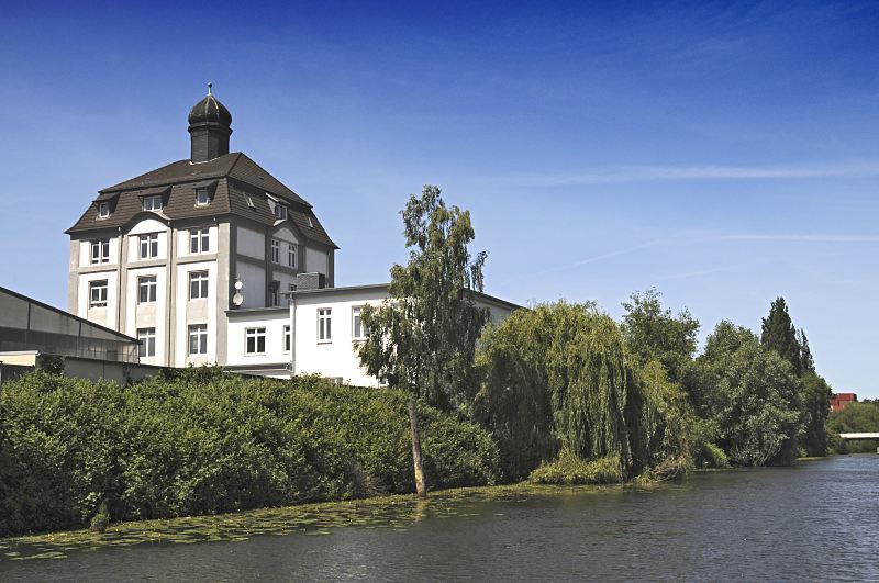 90-8695 |  Hamburg-Bilder aus dem Bezirk Hamburg-Mitte, Stadtteil Wilhelmsburg Bume am Ufer des Jaffe-Davids-Kanals - historische Architektur der Industrialisierung. Das Ufer des Jaffe-Davids-Kanals ist dicht mit Bschen und Bumen bewachsen. Die ste der Weiden hngen weit ber das Wasser des Wilhelmsburger Industriekanals. Am Ufer des Wasserwegs steht typische Architektur der Industrialisierung in der Grnderzeit. www.fotograf-hamburg.de 