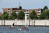 93-9604 |Bilder aus aus den Hamburger Stadtteilen - Schler und Schlerinnen der Schule Slomanstieg knnen auf dem Wasser des Mggenburger Zollhafens das Segeln lernen. Die Kinder sitzen in den Optimistenjollen und tragen signalrote Schwimmwesten - am Ufer des Hafens ein Wohngebude der Veddel. www.fotograf- hamburg.de