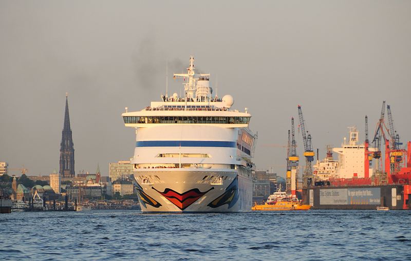 99-4886 |Schiffsfotos aus der Hamburg - Augen und Kussmund am Bug des Kreuzfahrtschiffs Aida Aura. Das Passagierschiff Aida Aura verlsst im Abendlicht den Hamburger Hafen; rechts ein Schwimmdock der Werft und links das Mahnmal der Kriegsruine der St. Nikolaikirche www.fotograf- hamburg.de