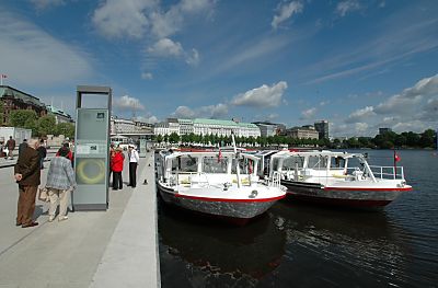 011_25824 | zwei weisse Schiffe der Hamburger Alsterflotte liegen am Anleger Jungfernstieg; Passanten / Touristen lesen den Abfahrtsplan der Alsterschiffe.