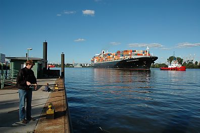 011_25833 | ein beladenes Containerschiff, wird mit einem Schlepper Richtung Container Terminal Altenwerder geschleppt; der Angler holt die Angelleine ein.