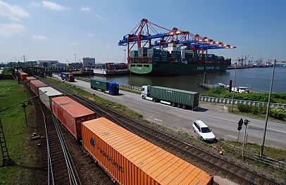 011_25941 |  Blick zum Eurogate Terminal am Waltershofer Hafen - ein beladener Container Carrier liegt am Kai - im Vordergrund ein langer Containerzug und auf der Strasse Lastwagen mit ihrer Containerladung. 