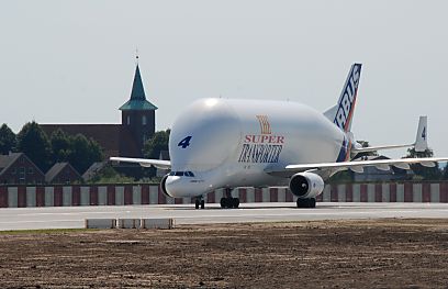 011_25965 | ein Airbus BELUGA Frachtflugzeug auf der fertig gestellten Starbahn / Landebahn Verlngerung. Im Hintergrund die St. Pankratiuskirche und eine Lrmschutzwand, die die Bewohner von Neuenfelde gegen den Fluglrm schtzen soll.